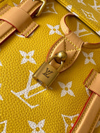 Louis Vuitton yellow monogram bag close-up of leather tabs and gold lock hardware