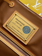 Louis Vuitton leather ID tag on yellow monogram bag with zipper track and brass rivets