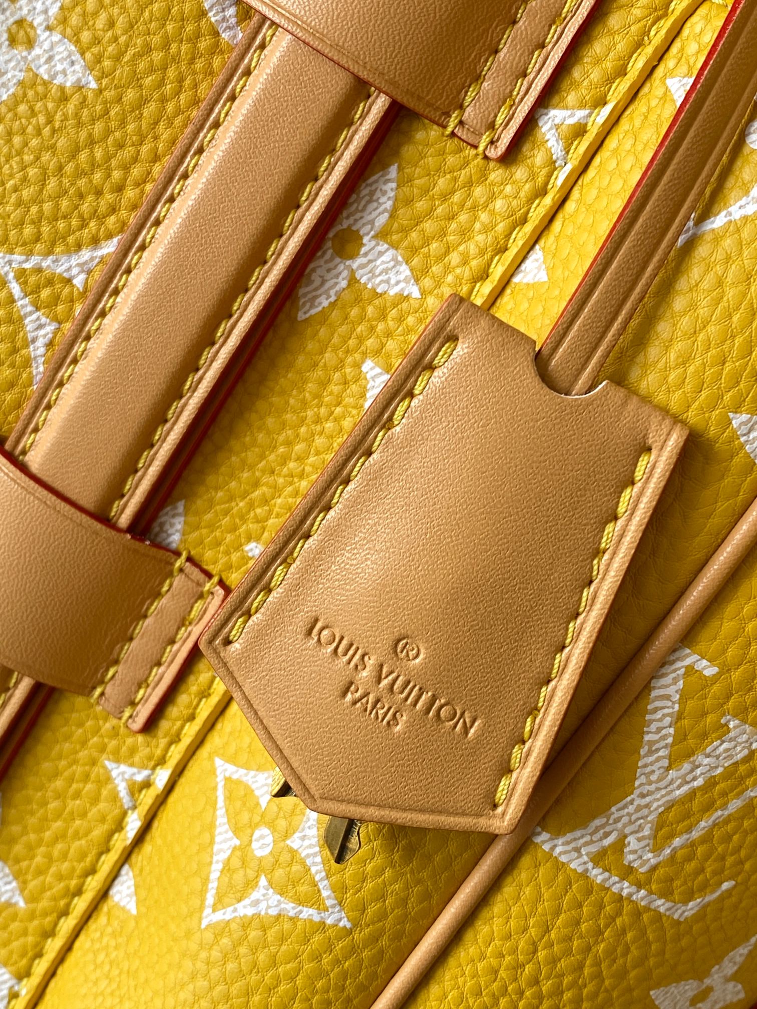 Louis Vuitton yellow monogram bag close-up of inner pocket and embossed logo patch