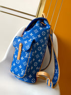 Louis Vuitton blue monogram bag with tan leather strap and top handle, angled view