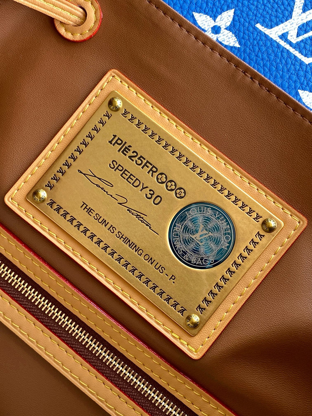 Louis Vuitton bag gold-tone nameplate on brown leather interior, stitched trim detail