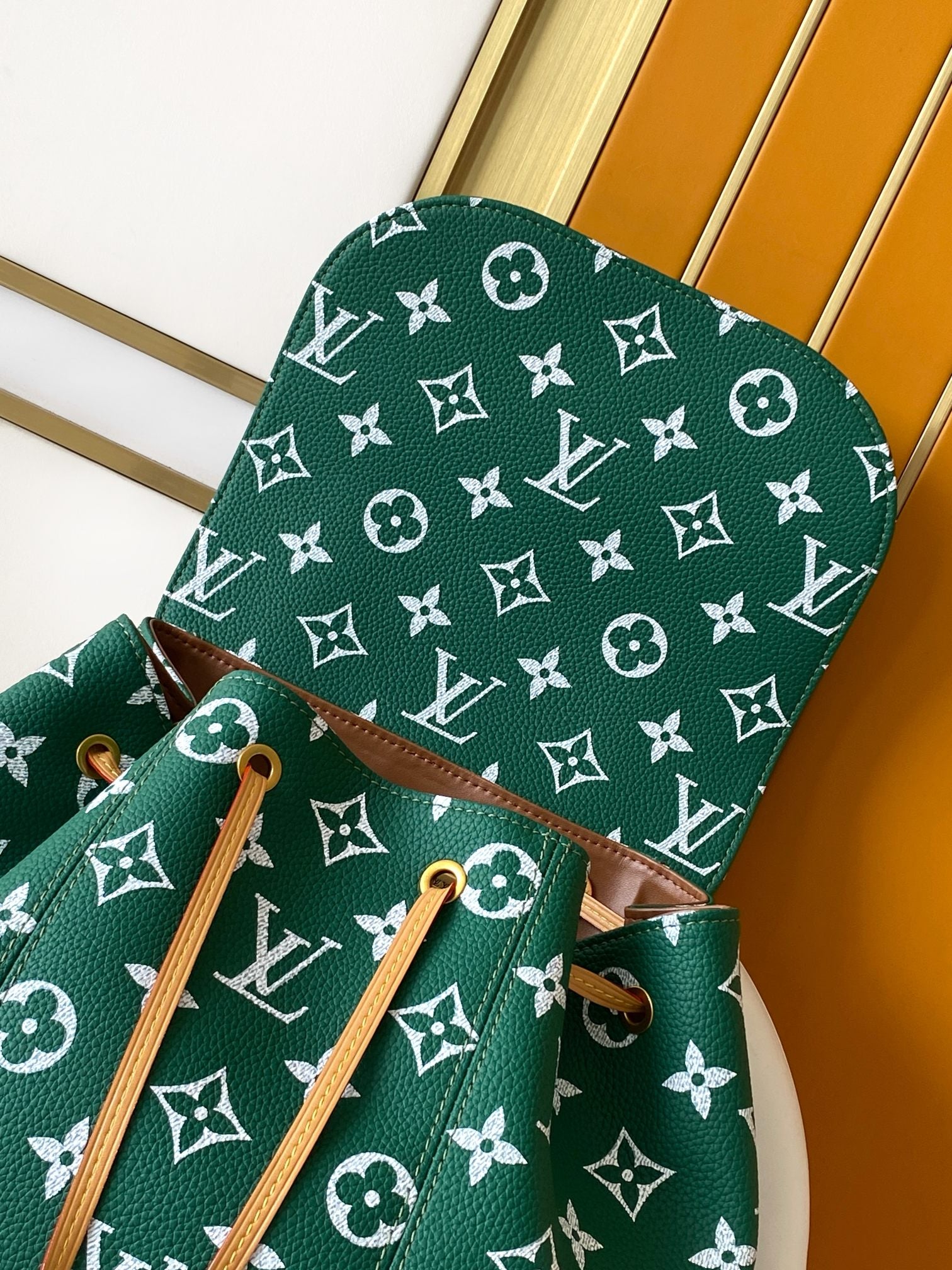 Louis Vuitton green monogram bag with tan straps and cinched top handle