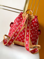 Louis Vuitton red monogram backpack bag with tan leather shoulder straps and handle.