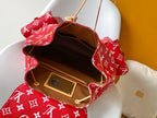 Louis Vuitton red monogram bag open to show tan leather interior and gold plaque.