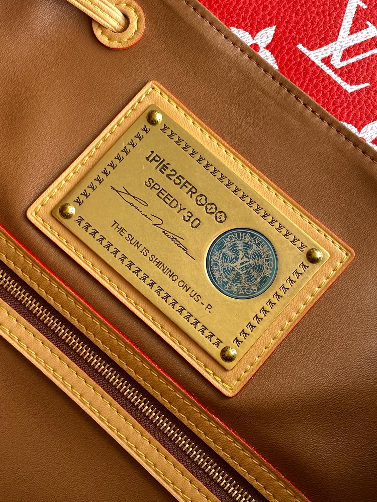 Louis Vuitton red monogram bag interior label with gold-tone nameplate and zipper edge.