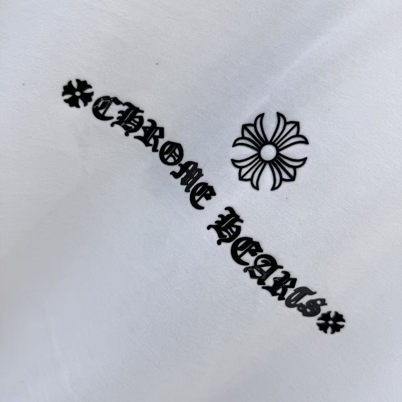Black graphic text with flower icon on white T-shirt