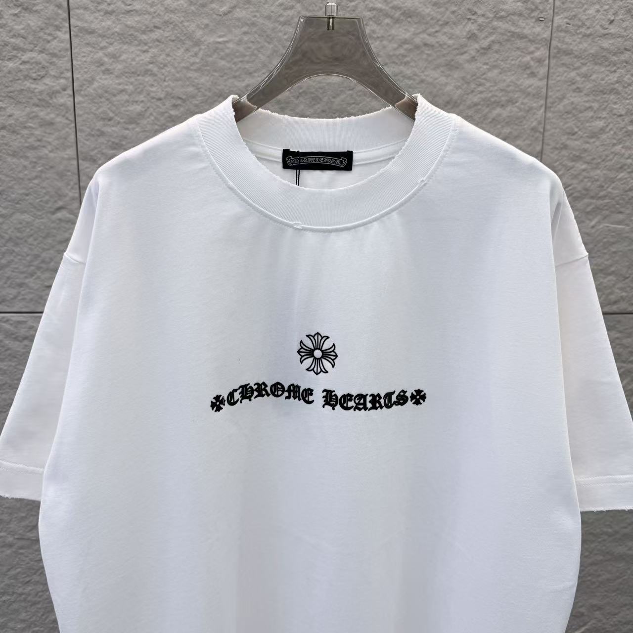 White T-shirt with crew neck and black chest logo with flower graphic