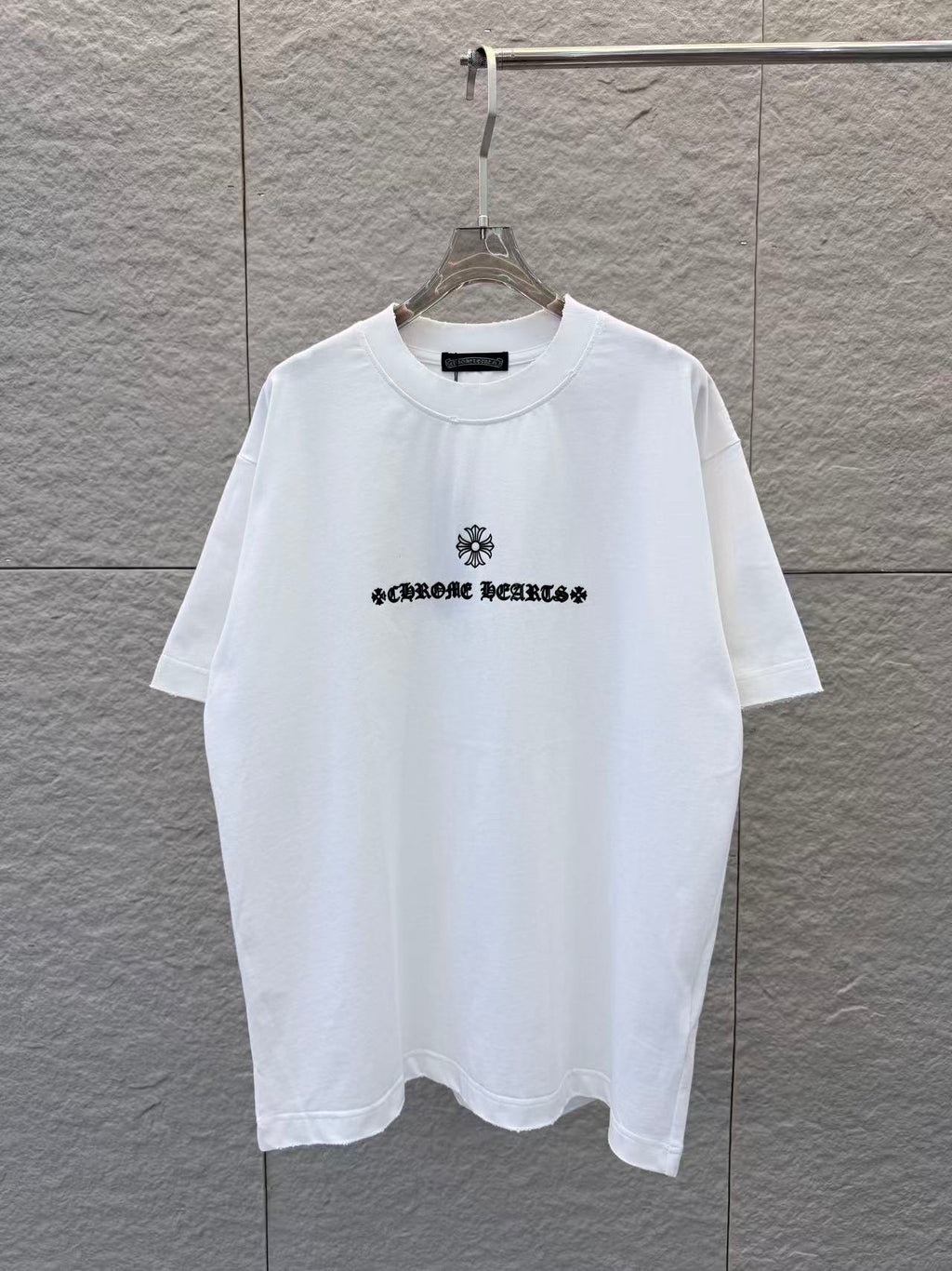 White short-sleeve T-shirt with small black chest graphic print