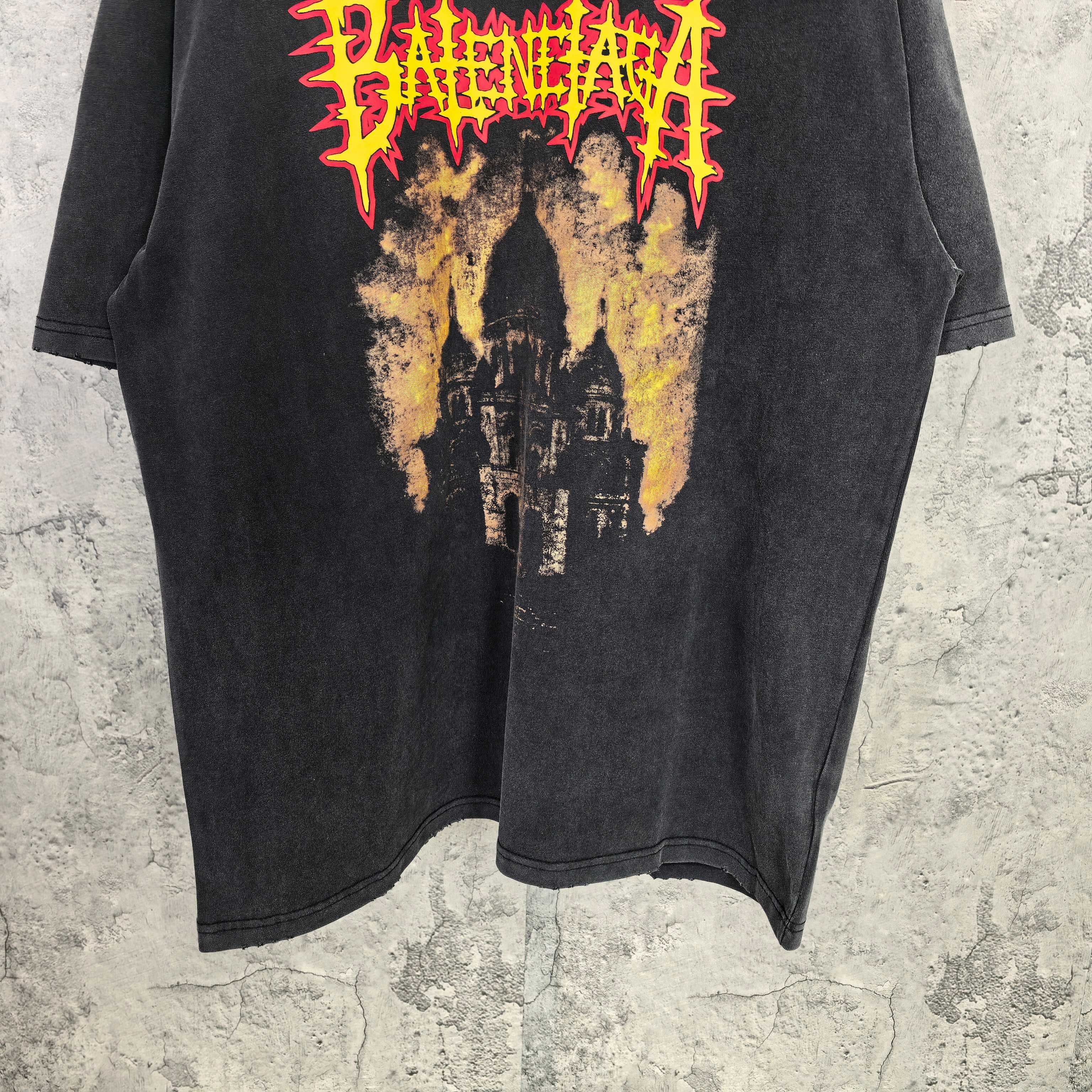 Black graphic T-shirt front with red/yellow cathedral print near hem