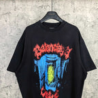 Black graphic T-shirt with colorful blue and yellow face artwork and red text