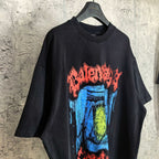 Black graphic T-shirt with blue and yellow face print and red arched text