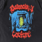 Close-up black T-shirt graphic: red arch text, blue drips, yellow center
