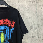 Black T-shirt side crop with partial multicolor face print in blue, yellow, red
