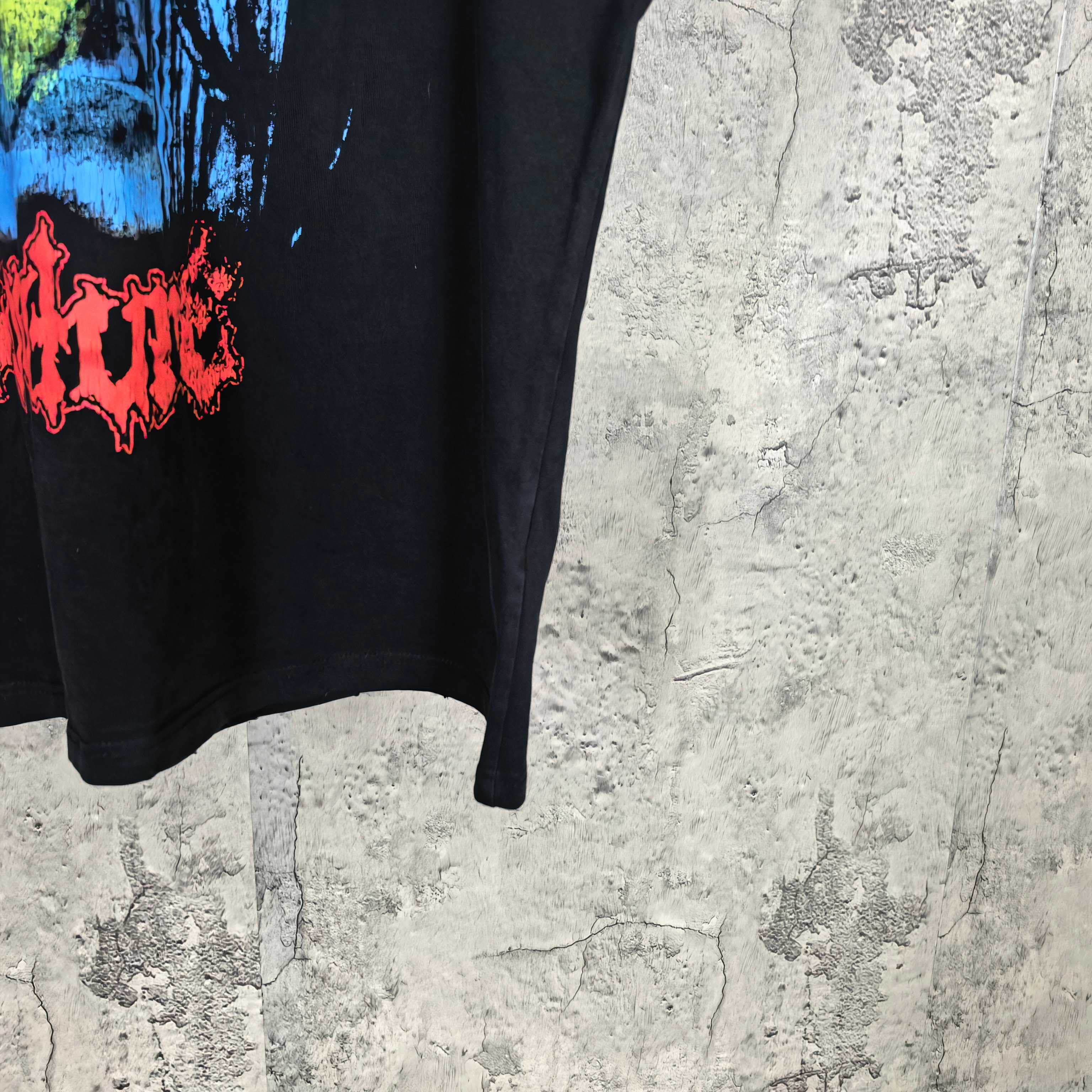 Black graphic T-shirt with red logo-style lettering on the left side