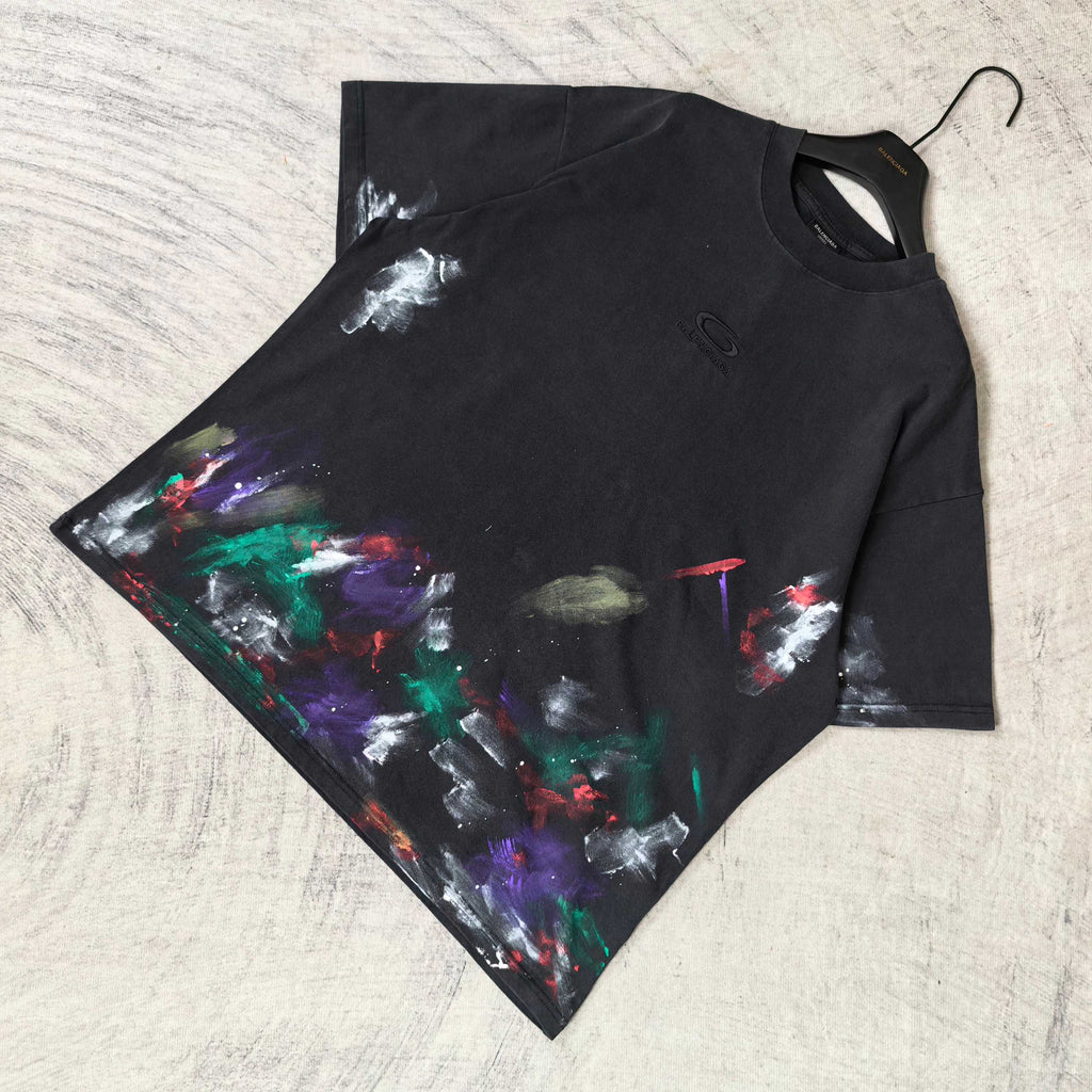 Balenciaga short-sleeve T-shirt laid flat, black with colorful abstract paint print