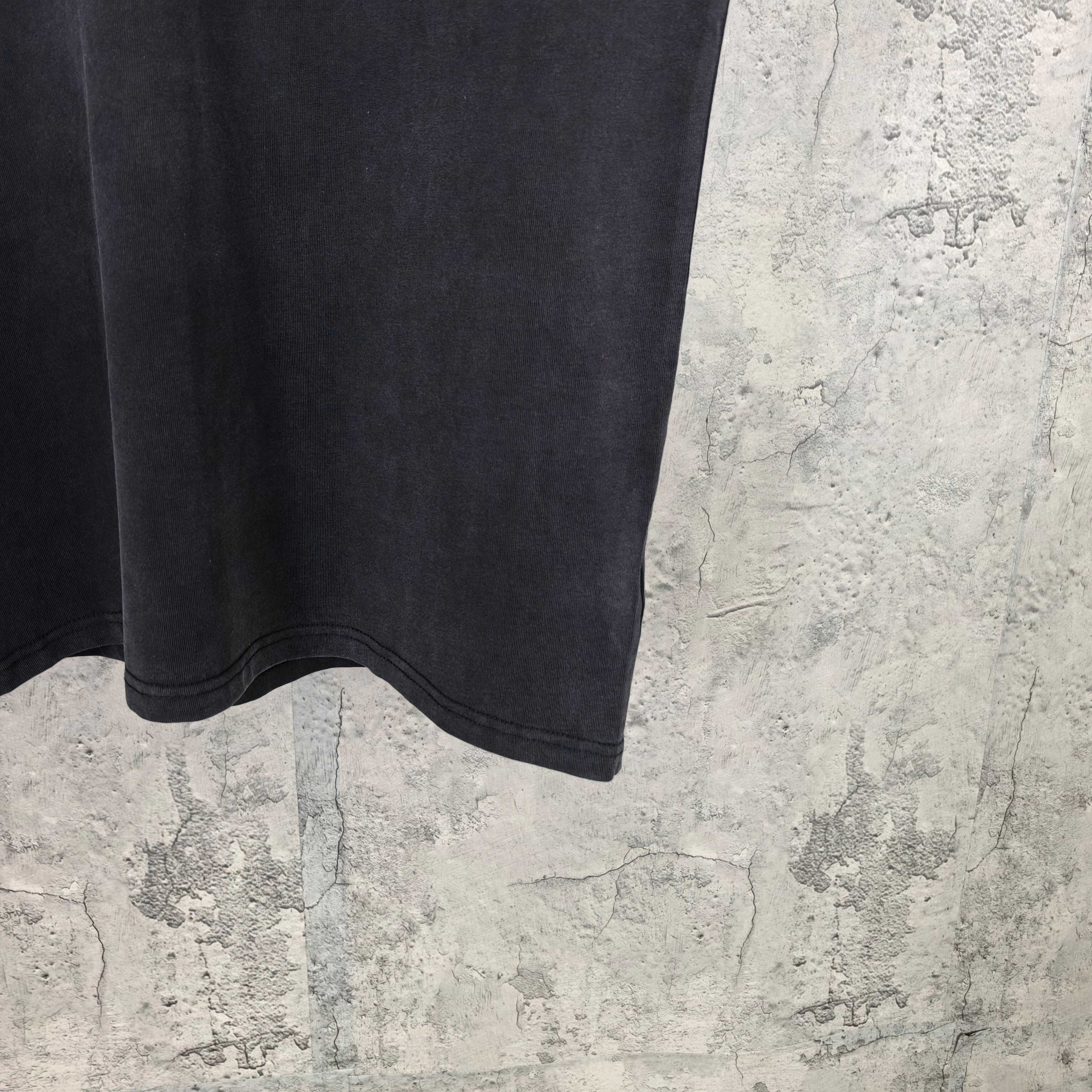 Black short-sleeve T-shirt hem and sleeve cuff detail, no visible logo.