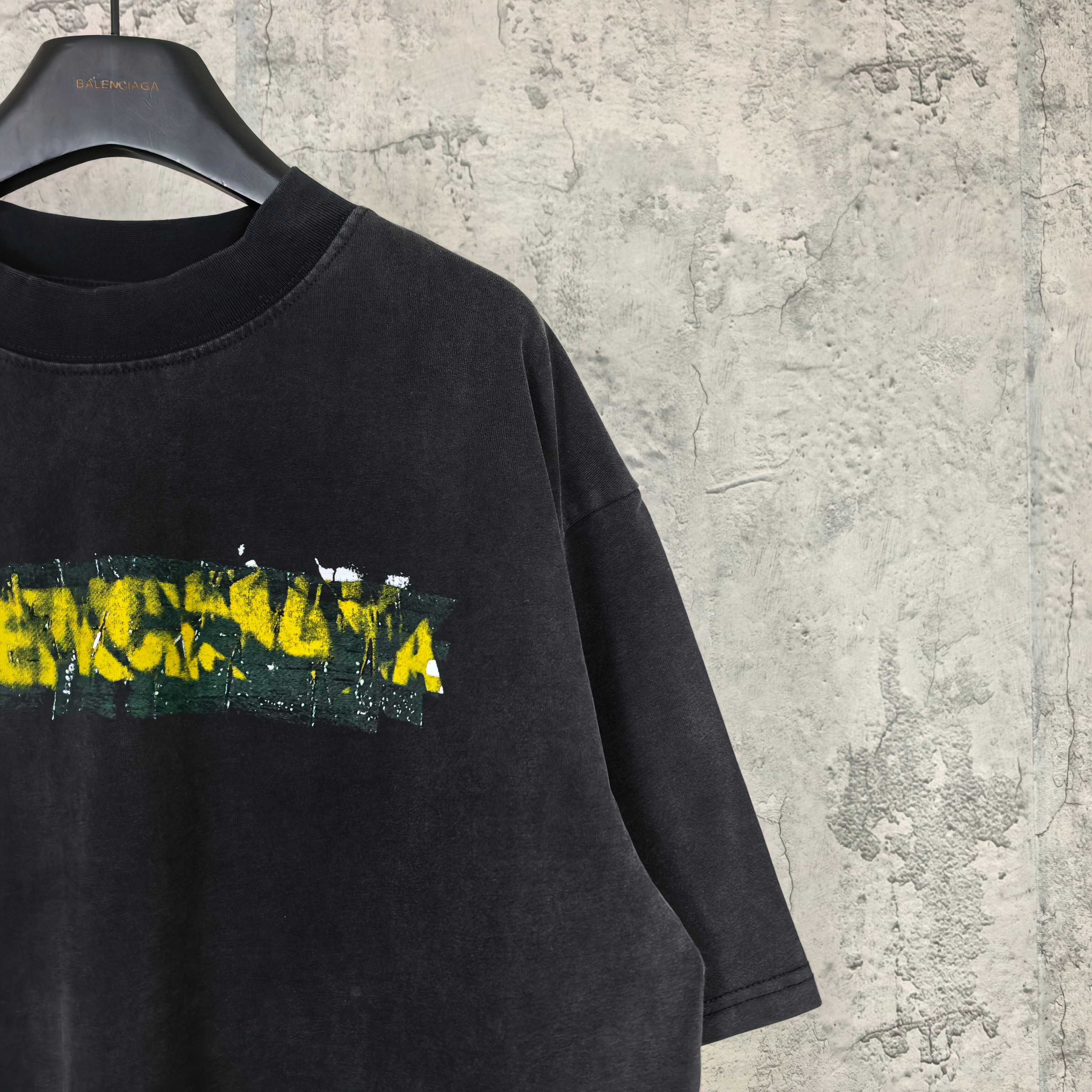 Black short-sleeve T-shirt close-up of Balenciaga logo graphic and crew neck.