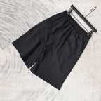 Black shorts with elastic waistband and loose drape, no visible front logos