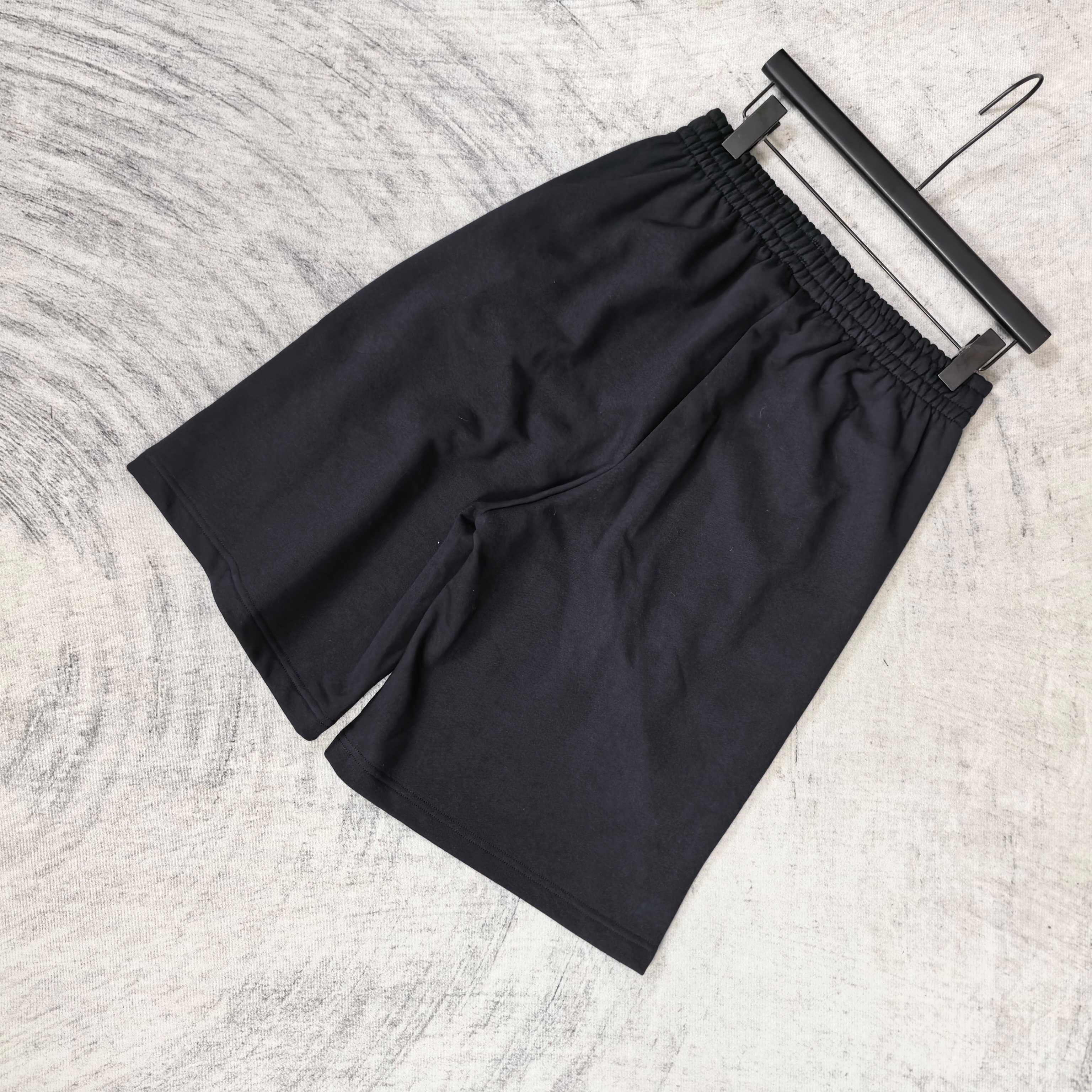 Black shorts with elastic waistband and loose drape, no visible front logos