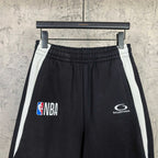 Black shorts with elastic waistband, white side stripes, NBA and Balenciaga emblems