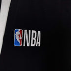 NBA logo patch on black shorts with white side stripe