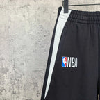 Black shorts with white side stripe, NBA logo on front panel, elastic waistband