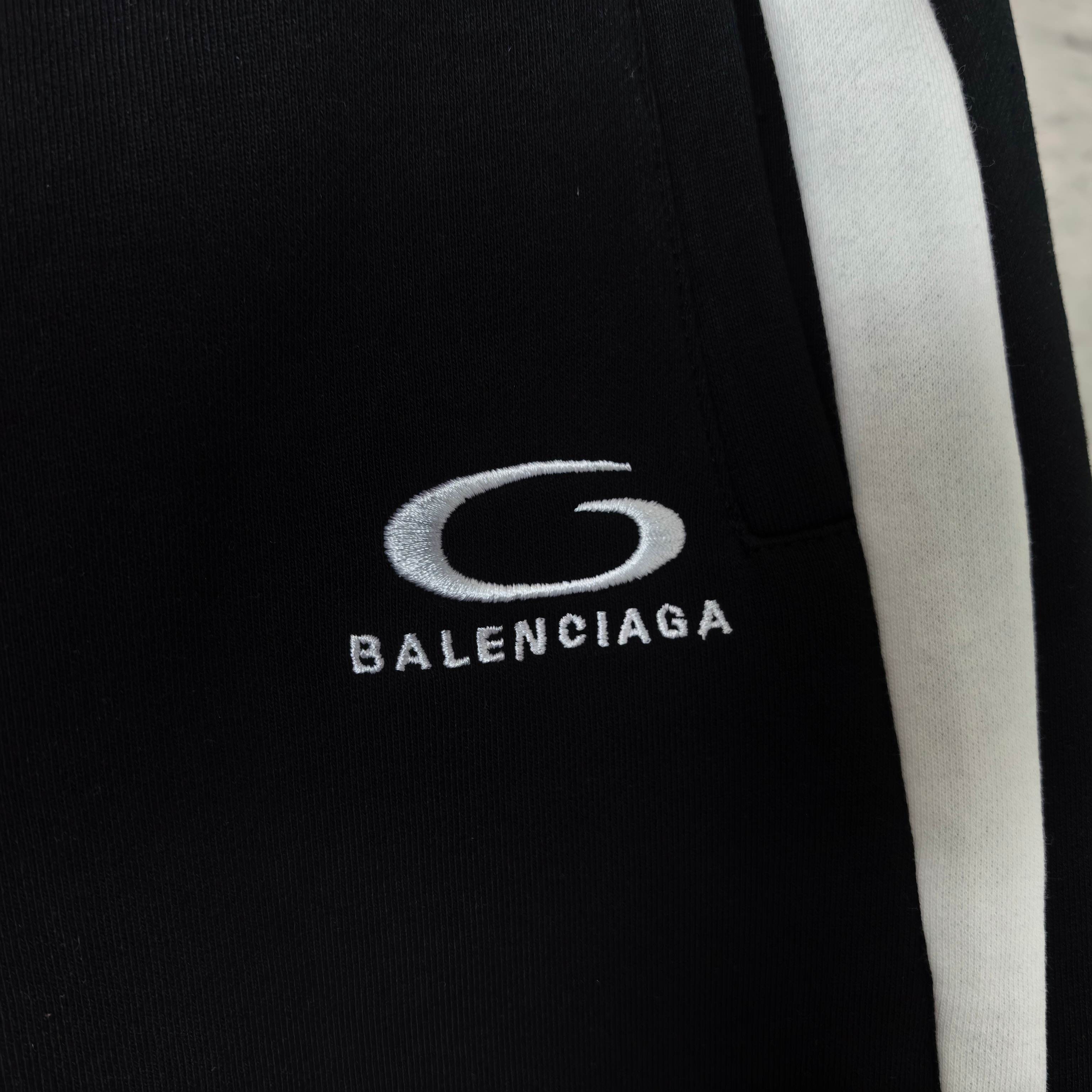 Balenciaga oval logo and text on black shorts, with white side stripe