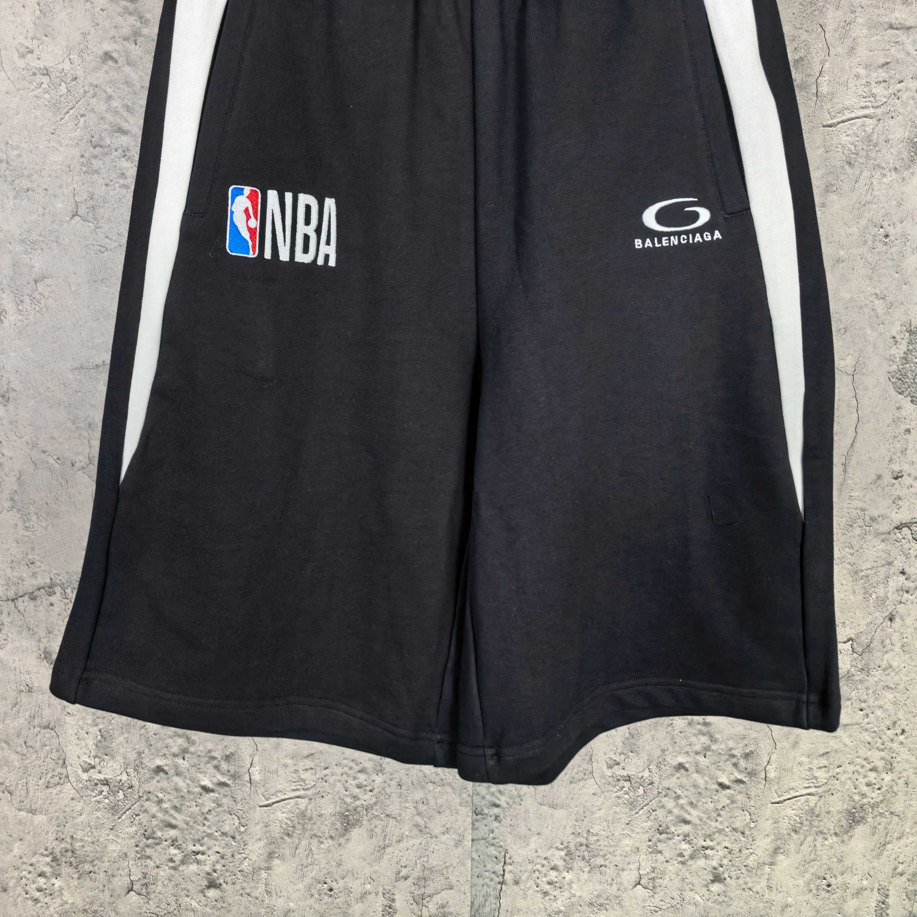 Black Balenciaga shorts with white side stripes, NBA and Balenciaga logos