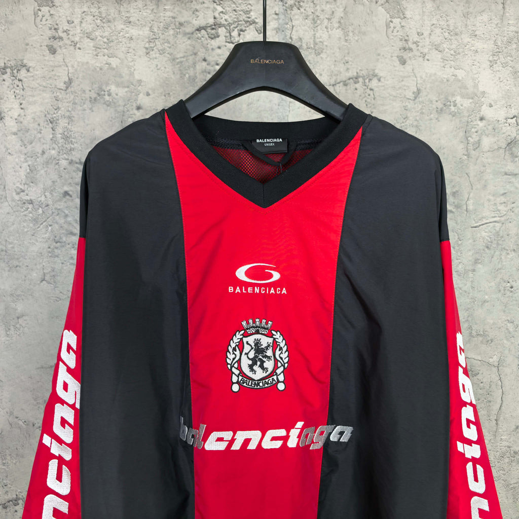 Long-sleeve Balenciaga jersey front view in red and black with crest emblem and text.