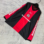 Long-sleeve Balenciaga jersey laid flat: black and red panels with sleeve text logos.