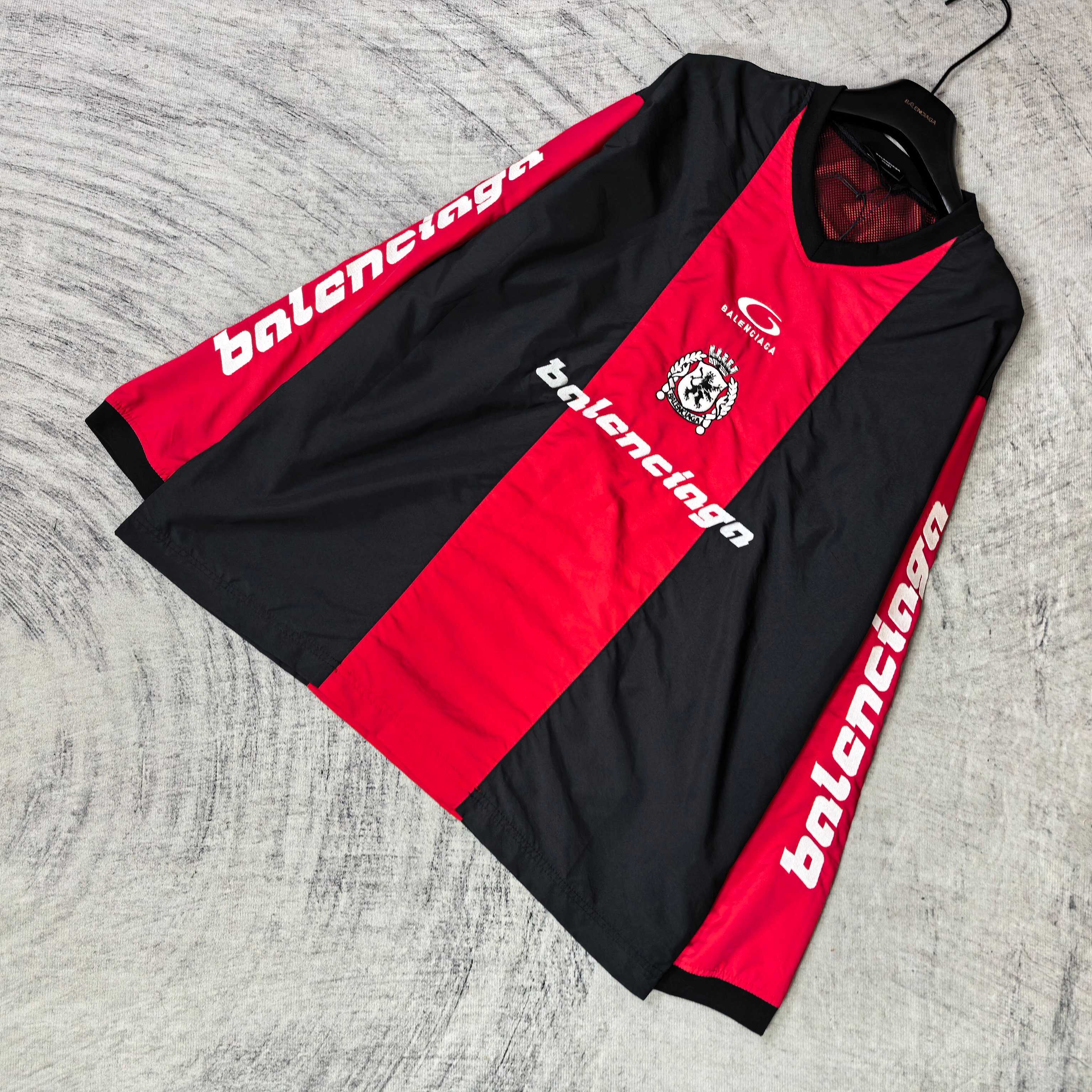 Long-sleeve Balenciaga jersey laid flat: black and red panels with sleeve text logos.