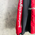 Balenciaga jersey sleeve close-up showing vertical red panel and bold white lettering.