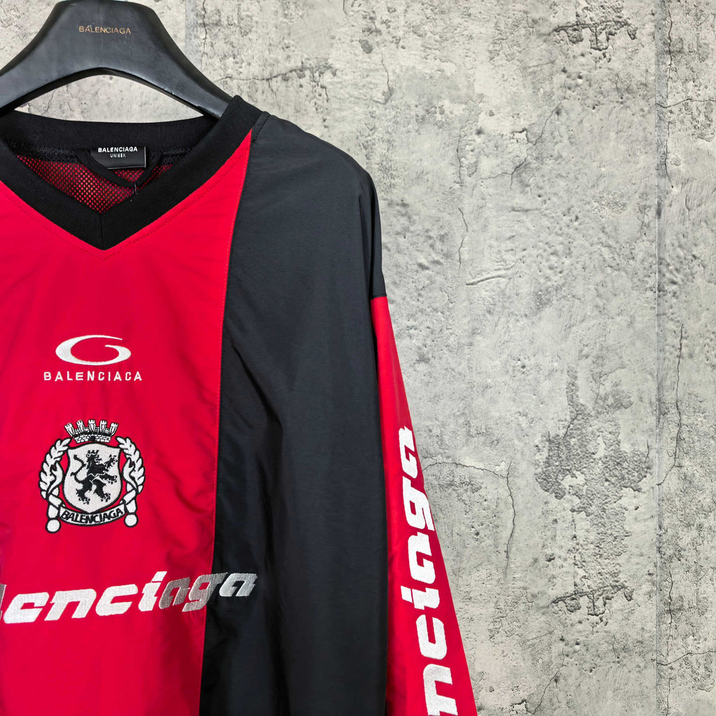 Balenciaga jersey side close-up with black sleeve, red panel, and vertical sleeve lettering.