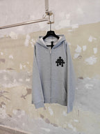 Light gray zip hoodie with black front cross emblem