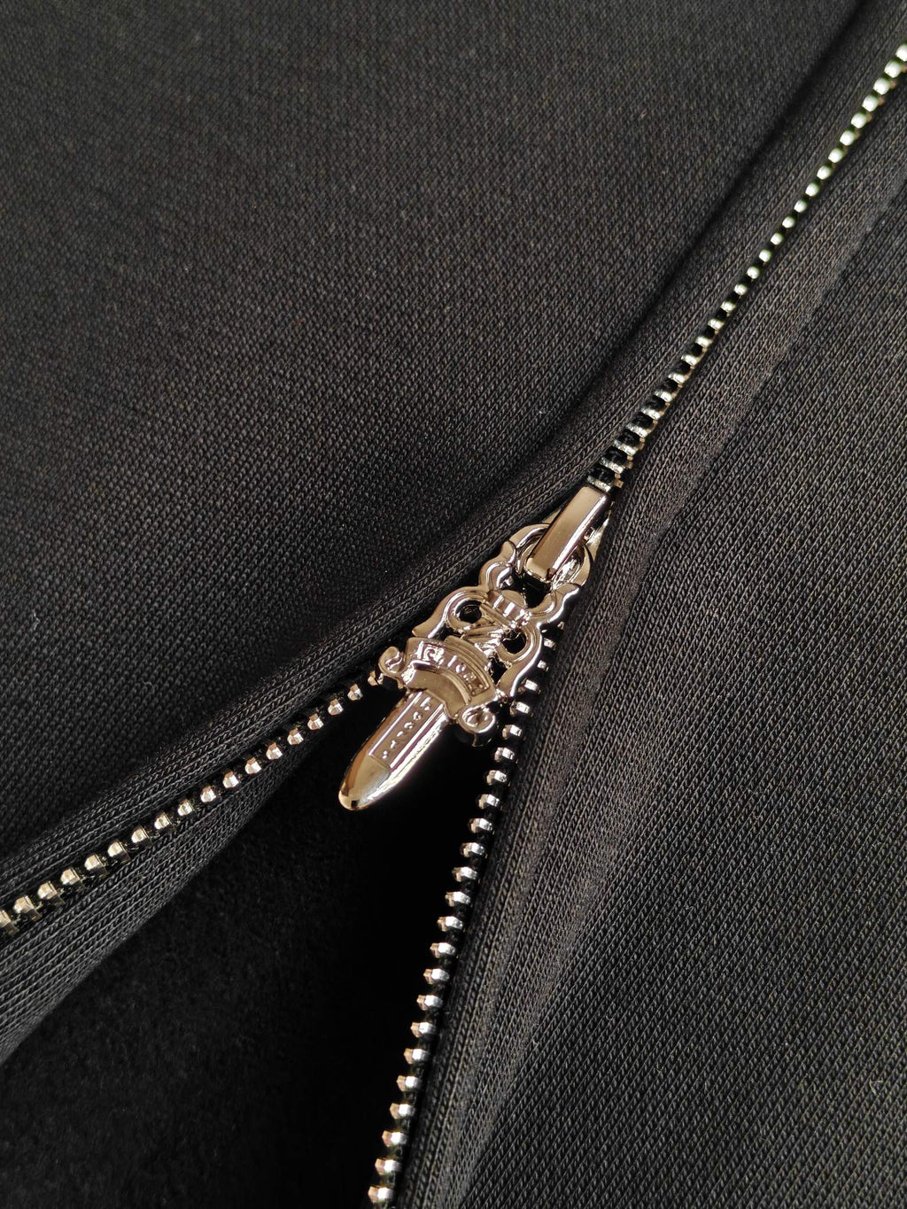 Gold-tone zipper with double sliders on dark hoodie