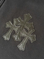 Embroidered cross appliques on dark hoodie fabric