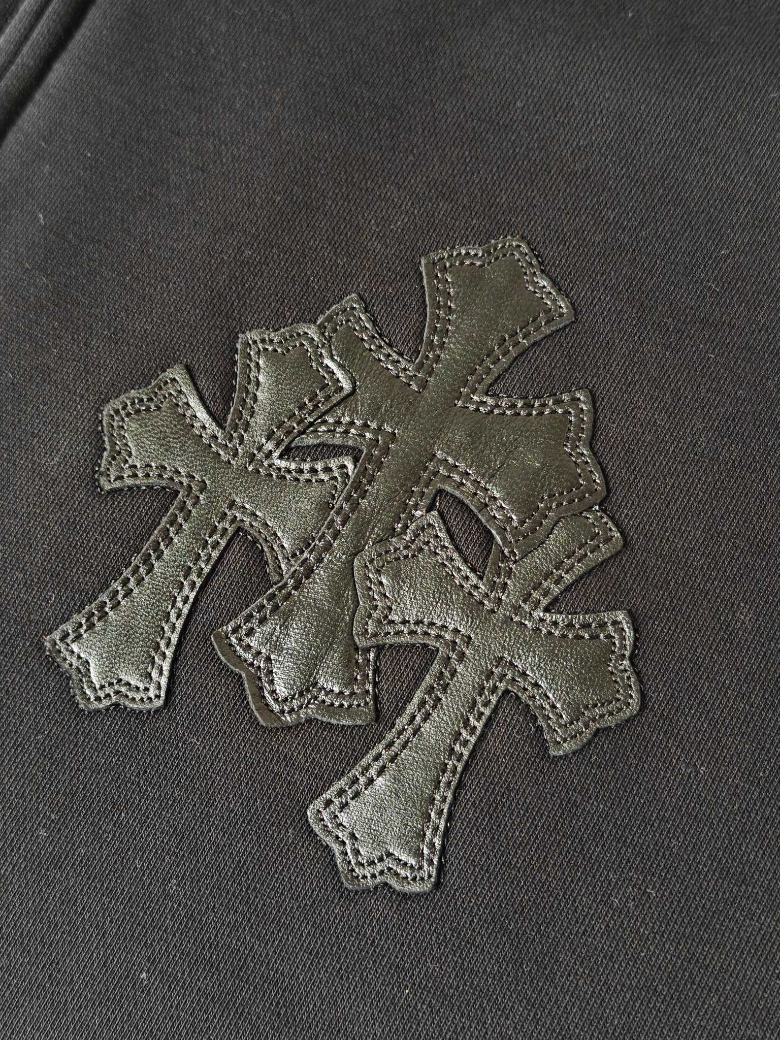 Embroidered cross appliques on dark hoodie fabric