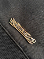 Metal logo label on dark hoodie fabric