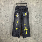 Dark denim pants with yellow and white cross graphics and speckled details