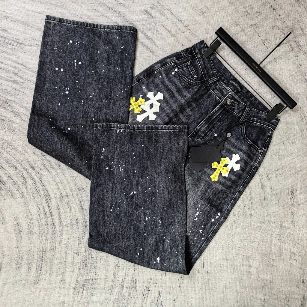 Dark denim pants folded with pockets and cross graphics in yellow and white