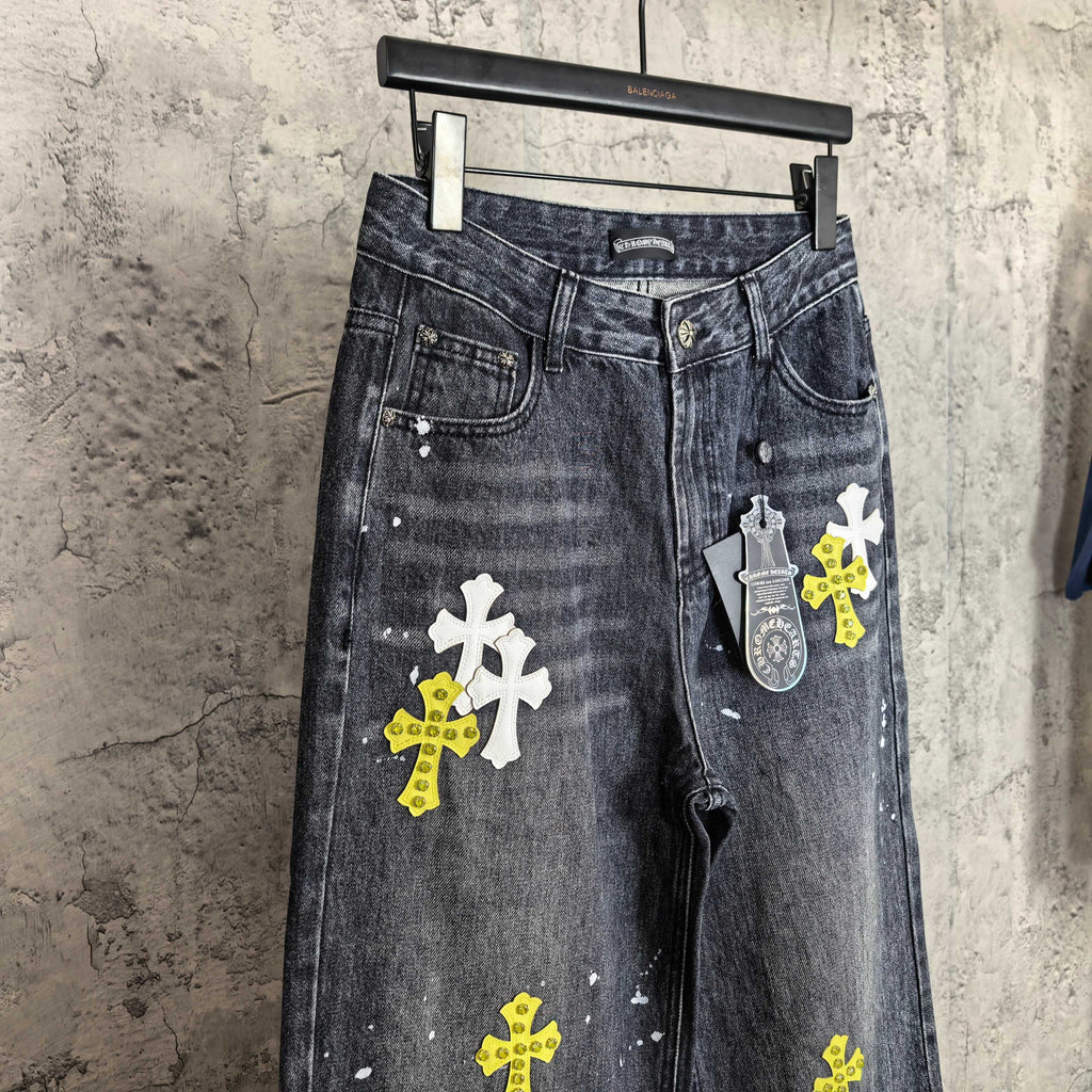 Dark denim pants with cross graphics and hanging tag print detail on right leg