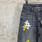 Dark denim pants close-up of pocket area with stacked yellow and white cross graphics