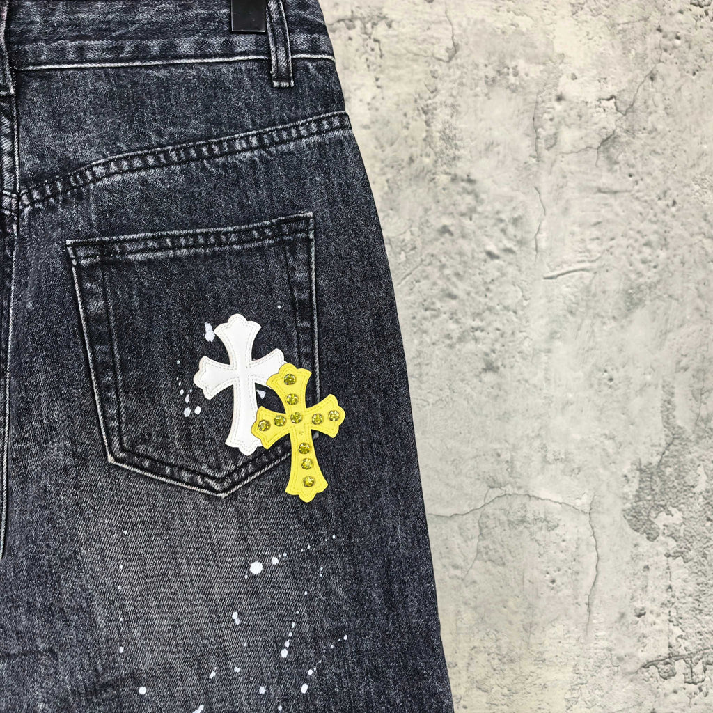 Dark denim pants with white and yellow cross patches on front pocket