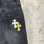 Dark denim pants with white and yellow cross patches on front pocket