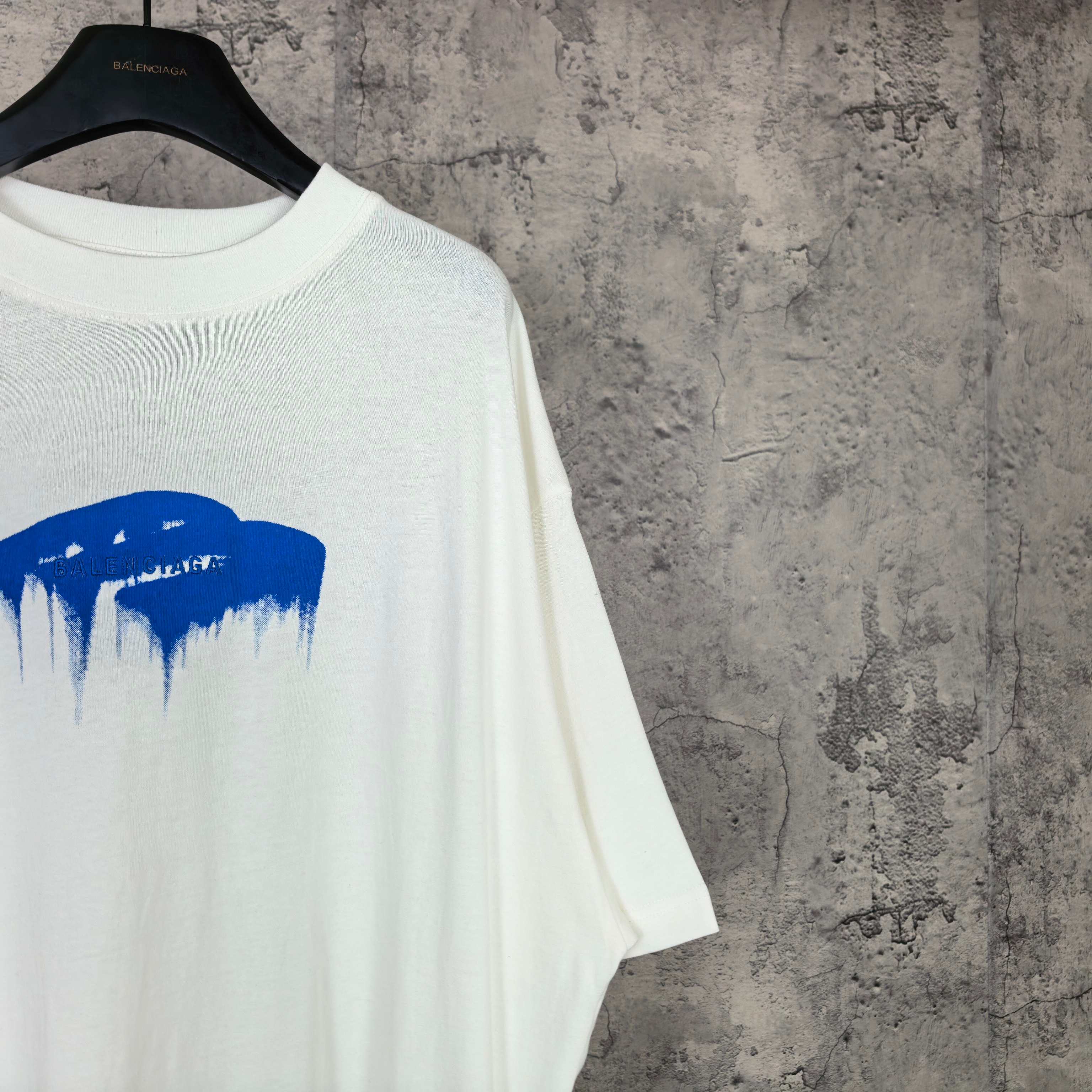 White short-sleeve T-shirt with blue drip graphic on the left chest