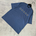 Balenciaga short-sleeve T-shirt, blue, folded; white star graphic on front.