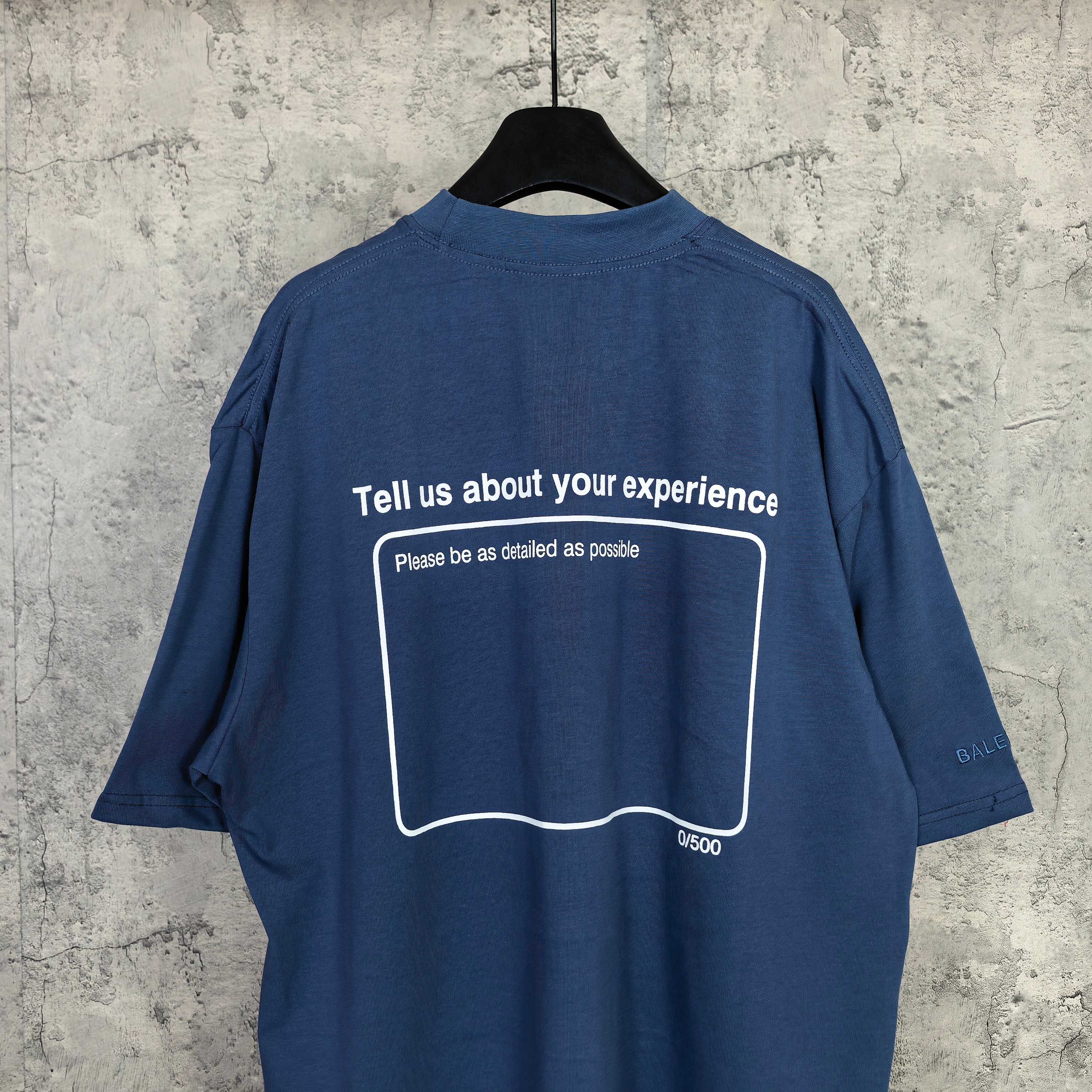Balenciaga short-sleeve T-shirt, blue; back has 'Tell us about your experience' outline box.