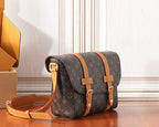 Monogram crossbody bag with tan strap, gold-tone hardware, and flap detail