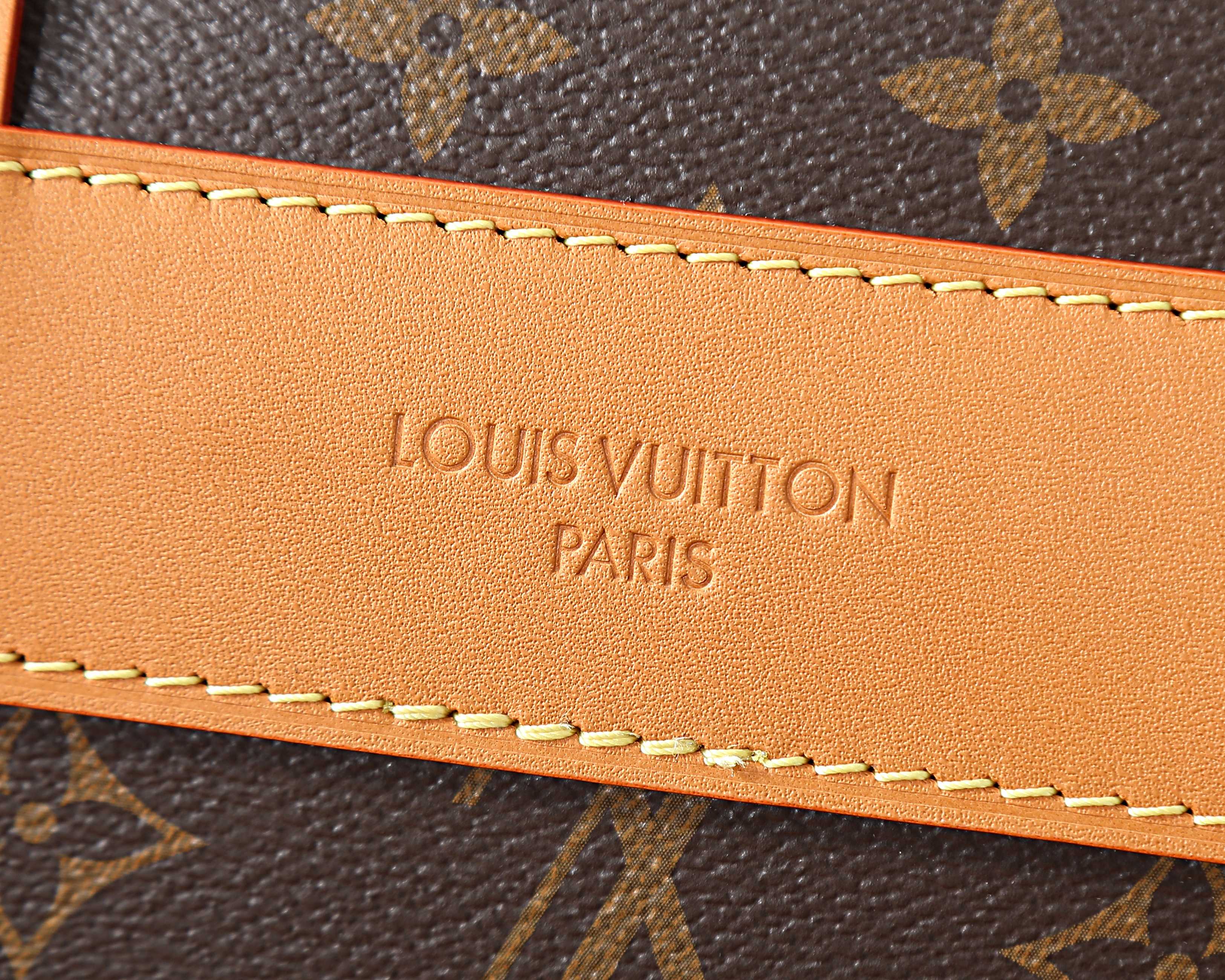 Leather logo patch with stitched trim on monogram crossbody bag edge