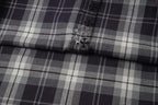 Long-sleeve shirt close-up of plaid panel and small button on placket